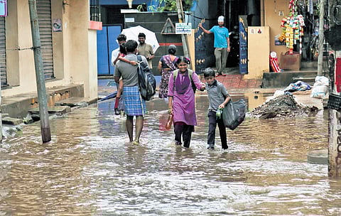 Students wading through an inundated street in Visakhapatnam