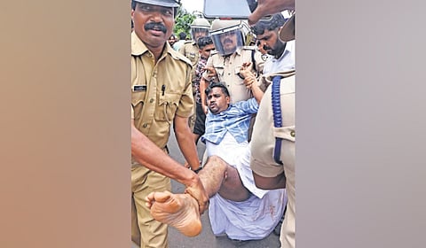 Police removing a UDF worker who was protesting in front of P P Divya’s house at Kannapuram in Kannur on Wednesday demanding her resignation