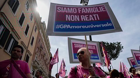 People hold banners reading "we are families not crimes" during a pro-surrogacy flash-mob in Rome.