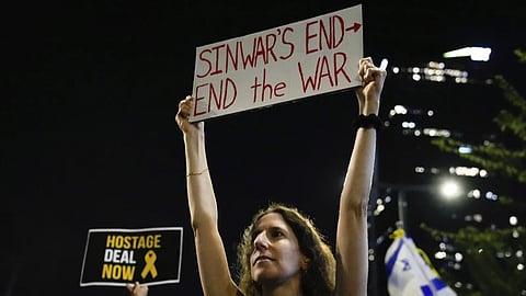 A demonstrator holds a sign about the killing of Hamas leader Yahya Sinwar during a protest calling for a cease-fire deal and the immediate release of hostages held by Hamas on Thursday, Oct. 17, 2024, in Tel Aviv, Israel.