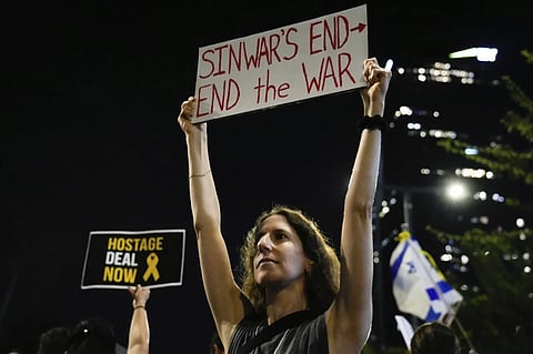 A demonstrator holds a sign about the killing of Hamas leader Yahya Sinwar during a protest calling for a cease-fire deal and the immediate release of hostages held by Hamas on Thursday, Oct. 17, 2024, in Tel Aviv, Israel.