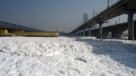 Toxic foam floats on the surface of the polluted Yamuna River at Kalindi Kunj in New Delhi.