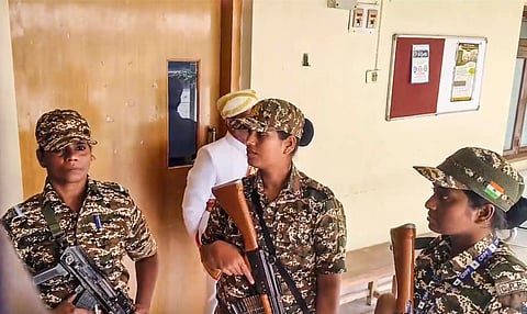 Security personnel stand guard during a raid by the Enforcement Directorate on the Mysuru Urban Development Authority (MUDA) office in connection with a money laundering case, in Mysuru, Karnataka, Friday, Oct. 18, 2024.