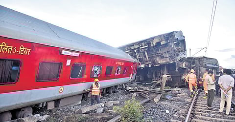 Indian railway workers restoring the site by pushing the coaches of the Mysuru-Darbhanga Bagmati Express train derailed at the Kavaraipettai Railway Station.