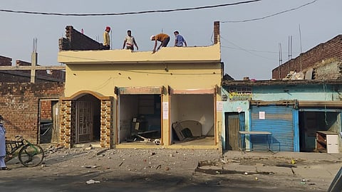 Residents dismantle a building after PWD pasted notices on the properties of several people asking them to remove any illegal construction.