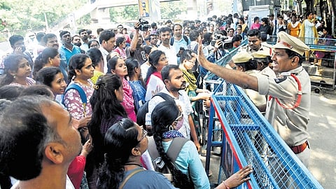 Aspirants wait outside the examination centre at Government Degree College for Women in Begumpet, Hyderabad, on Monday