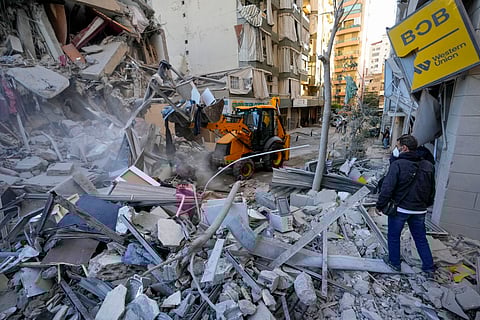 Rescue workers use a bulldozer to remove rubble of destroyed buildings at the site of an Israeli airstrike on Sunday night that hit several branches of the Hezbollah-run al-Qard al-Hassan in Beirut's southern suburb, Lebanon.