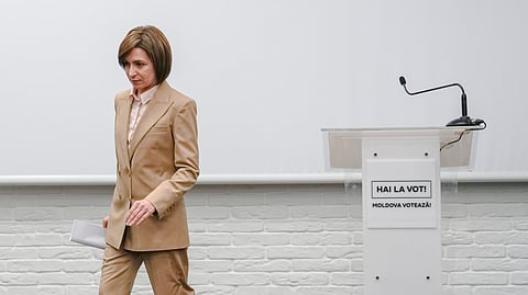 Moldova's President Maia Sandu leaves after delivering a speech during a press briefing.