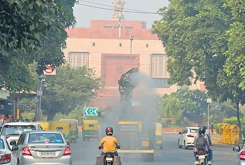 Anti-smog gun spraying water droplets near Parliament House.