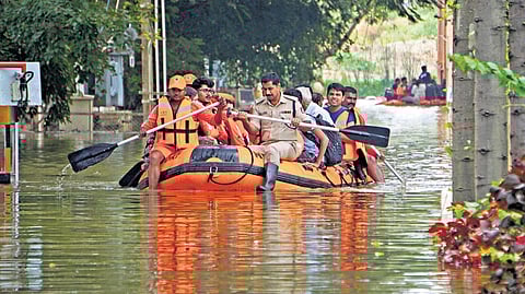 Rescuers move residents to safety on a dinghy, after the Kendriya Vihar apartment complex got flooded due to heavy rain in Yelahanka, Bengaluru, on Tuesday