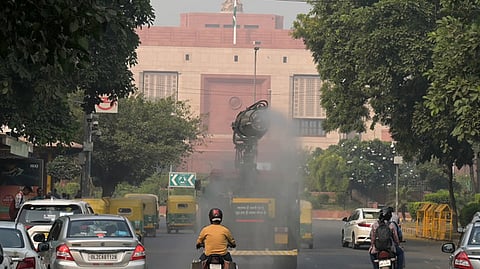 An anti-smog gun being used to spray water droplets to curb air pollution, near Parliament house in New Delhi.