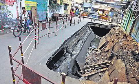 A boy rides his bicycle past the caved-in road at Chaknavadi
in Goshamahal, Hyderabad, on Wednesday