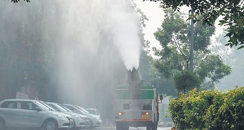 A mobile van sprinkling water to curb air pollution.
