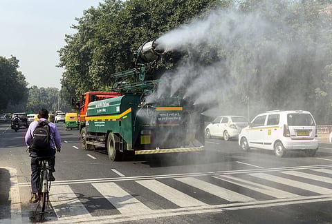 An anti-smog vehicle sprinkles water to curb air pollution amid deteriorating air quality, in New Delhi.