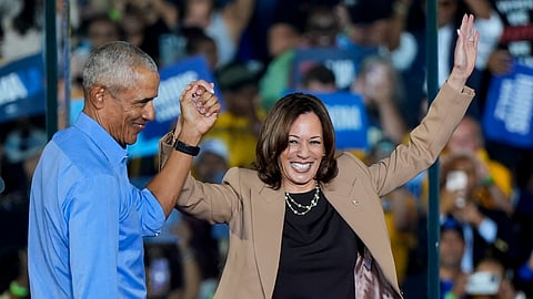 Former US President Barack Obama holds hands with Democratic presidential nominee Kamala Harris after introducing her to speak during a campaign rally for Harris on Thursday, Oct. 24, 2024, in Clarkston, Georgia.