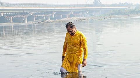 Delhi BJP President Virendra Sachdeva takes a dip in the Yamuna river to mark his protest against the Delhi government with the rising pollution in the river as well as the city, in New Delhi on Thursday.