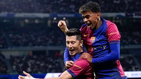 Barcelona's Robert Lewandowski celebrates after scoring his side's second goal with Lamine Yamal, right, during a Spanish La Liga soccer match between Real Madrid and Barcelona at the Santiago Bernabeu stadium in Madrid, Spain, Saturday, Oct. 26, 2024.