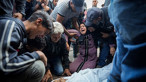 Palestinians mourn their relatives killed in the Israeli bombardment of the Gaza Strip at a hospital morgue in Deir al-Balah, Tuesday