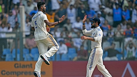 India's Virat Kohli (R) and Washington Sundar celebrate after the dismissal of New Zealand's captain Tom Latham during the first day of the third Test cricket match between India and New Zealand at the Wankhede stadium in Mumbai on November 1, 2024.