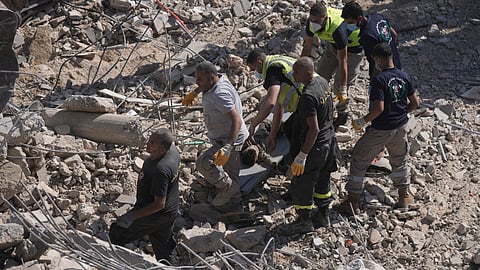 Rescue workers carry the body of a boy who was found under the rubble of a destroyed building that was hit Tuesday night in an Israeli airstrike, in Sarafand, south Lebanon.