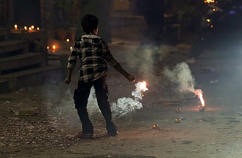 A child bursts firecrackers during the celebration of Diwali festival, in New Delhi, Thursday, Oct. 31, 2024.