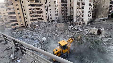 A municipality worker uses a bulldozer to remove the rubble of a destroyed building that was hit in an Israeli airstrike on Dahiyeh, in the southern suburb of Beirut.