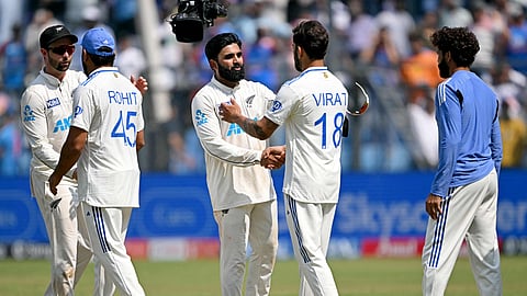 New Zealand's Ajaz Patel (3L) and Devon Conway (L) shake hands with India's Virat Kohli (2R) and captain Rohit Sharma (2L) at the end of the third and final Test between India and New Zealand