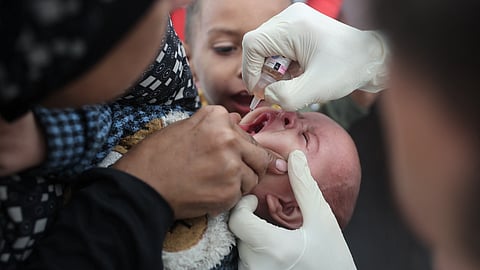 A medic administers a polio vaccine to a Palestinian child at Abdel Aziz Rantissi hospital in Gaza City's Nasr district, which was reopened on November 2, 2024, after sustaining heavy damage in Israeli bombardment of the area.
