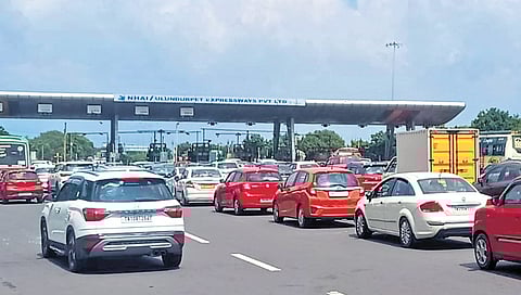 Vehicles line up in multiple lanes at Vikravandi toll plaza