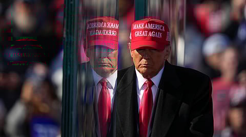 Republican presidential nominee former President Donald Trump is reflected in the bullet proof glass as he finishes speaking at a campaign rally in Lititz, Pa.