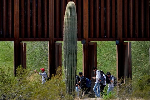 A group claiming to be from India walk past open border wall storm gates after crossing through the border fence in the Tucson Sector of the U.S.-Mexico border, Aug. 29, 2023