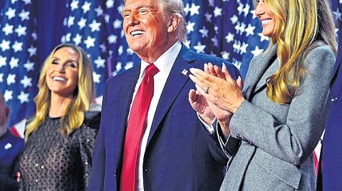 Donald Trump stands on stage with former first lady Melania Trump, as Lara Trump watches, at an election night watch party on Wednesday.