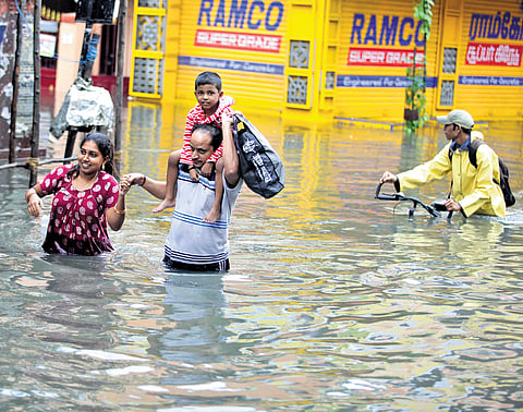 People travel through inundated roads in Choolaimedu during 2015 floods