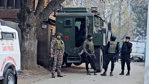 Security personnel stand guard during an encounter with terrorists at Sopore, in Baramulla district.
