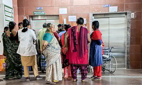 Employees and patients waiting before a lift at the Mahatma Gandhi Memorial Government Hospital in Tiruchy on Friday