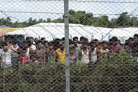 Rohingya refugees gather near a fence during a government organized media tour, to a no-man’s land between Myanmar and Bangladesh, near Taungpyolatyar village, Maung Daw, northern Rakhine State, Myanmar, June 29, 2018.