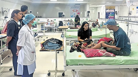 Siya Gupta sitting beside a patient