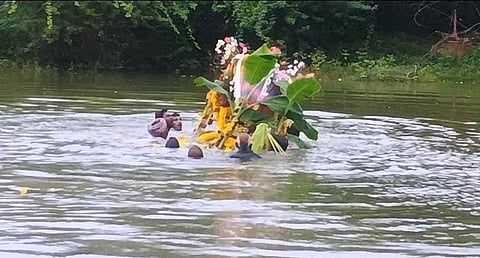 Villagers carry the body in neck-deep water