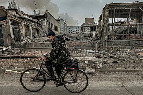 A man rides on a bike in front of the mail office which was destroyed by a Russian airstrike in Kurakhove, Donetsk region, Ukraine, on Nov. 7, 2024.