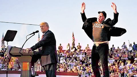 Tesla CEO Elon Musk (R) jumps on stage as he joins Republican presidential candidate Donald Trump during a campaign rally at the site of his first assassination attempt in Butler, Pennsylvania, on October 5, 2024.
