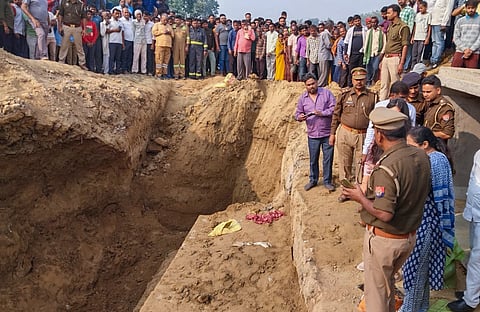 Police personnel conduct investigation as people gather after a mound of mud collapsed, in Kasganj, Uttar Pradesh, Tuesday, Nov 12, 2024. At least 4 people have died in the tragedy and several sustained injuries, according to officials.