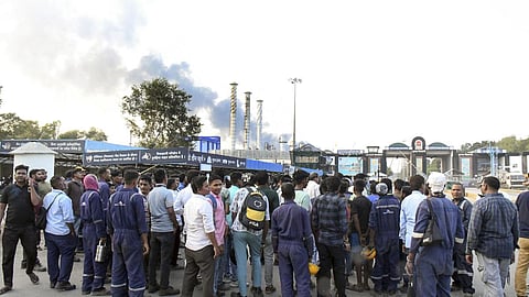 Workers wait outside after an explosion at the Indian Oil Corporation (IOCL) refinery in Vadodara