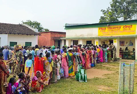 People wait to cast their votes for the first phase of Jharkhand Assembly polls, in West Singhbhum district