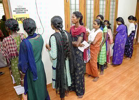 Tribal voters wait to cast their votes for the Wayanad Lok Sabha by-poll, Wednesday, Nov. 13, 2024.