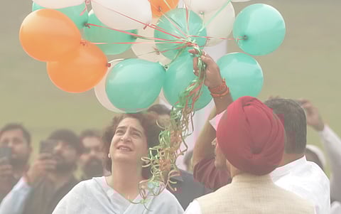 Congress leader Priyanka Gandhi Vadra looks on as balloons are released on the birth anniversary of India's first prime minister Jawaharlal Nehru, at Shanti Van in New Delhi, Thursday, a thick envelope of smog can be seen in the photo.