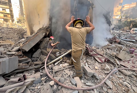 Firefighters try to extinguish a fire as smoke rises from a destroyed building that was hit in an Israeli airstrike in Dahiyeh, in the southern suburb of Beirut, Lebanon, Thursday, Nov. 14, 2024.