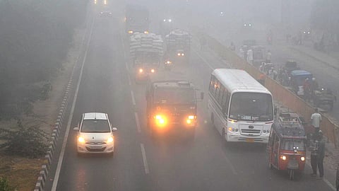 Vehicles ply on the Delhi-Agra National Highway amid fog, in Mathura, Thursday.