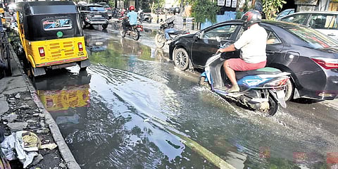 Vehicles pass through rainwater mixed with sewage at Nungambakkam