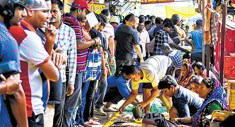 People in large numbers crowd the Unit-IV market to buy fish and meat for Chhadakhai in Bhubaneswar on Sunday