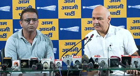 AAP MLA Raghuvinder Shokeen with party leader Manish Sisodia at a press conference in New Delhi on Monday.